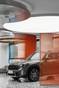 A modern showroom featuring a car display surrounded by a metal grid interior design