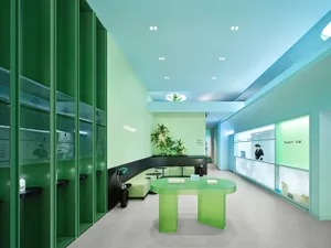 A modern office space with green-themed decor and furniture, featuring a green table, green walls, and green shelves.