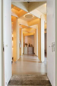 Modern interior renovation featuring reclaimed wooden walls, floors, and columns, with a contemporary design aesthetic.