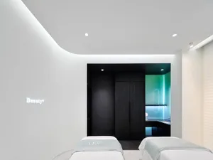 一間現代水療護理室，擁有白色壓克力牆面與簡約設計。