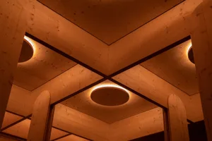 Multiple round wooden lights mounted in a row on a wooden ceiling