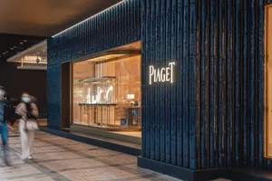 以金屬瓷磚打造的店面，搭配Piaget的燈光招牌。