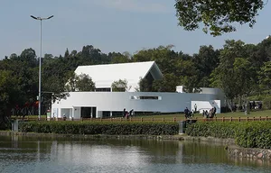 A modern public library with white concrete walls and a curved design.
