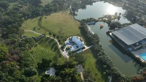 Aerial view of a park with a pavilion, greenery, and water features and structures.