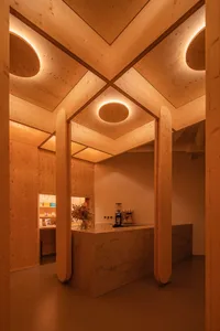 Lobby area of a coffee shop with wooden walls and a circular light fixture.