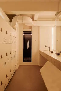 Modern minimalist locker room with white marble and concrete surfaces, showcasing sleek design elements.