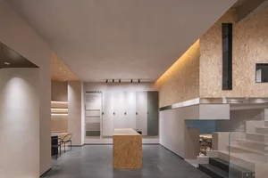 Modern retail shop featuring a concrete floor and walls adorned with wooden elements and illuminated by LED lighting.