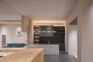 Modern kitchen interior with marble countertops and shelves.