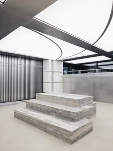 A modern industrial interior space featuring concrete steps and a minimalist design.
