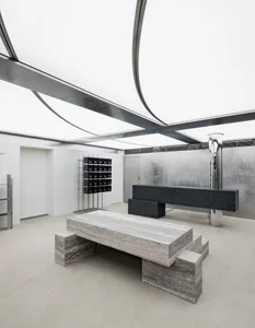 Minimalist concrete furniture and metal structures within an industrial interior design space.