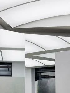 A modern office with a glass roof featuring geometric shapes and natural light.