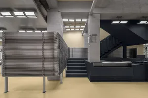 A spacious, industrial-style lobby featuring metal columns and modern design elements.
