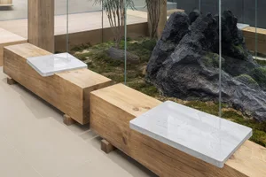 Modern minimalist interior featuring wooden furniture and white marble surfaces.