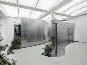 A modern, metal-walled architectural installation with green plants.