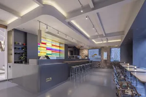 Modern restaurant interior with concrete, glass, and metal elements.