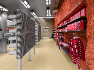 A retail shop interior featuring modern metal shelves, concrete walls, and steel shelves