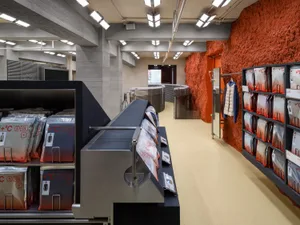 A modern retail space with concrete walls and black metal shelves.