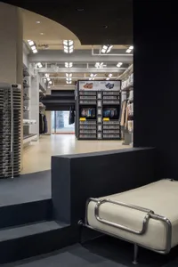 A modern retail space with concrete shelves, showcasing clothing and accessories.