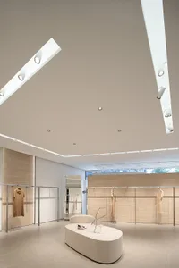 Modern retail store with clothing racks, minimalist decor, and neutral color palette.