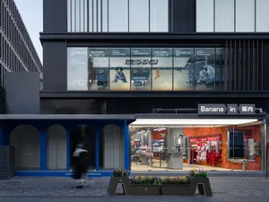 A modern retail storefront with glass windows displaying clothing and accessories.