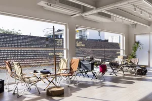 Modern, foldable chairs arranged on a wooden platform with outdoor elements in the background.