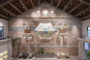 An industrial-style interior space featuring a brick wall and wooden beams.