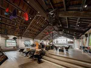 寬敞的工業風展示間，搭配木質地板、金屬與玻璃展示櫃，以及混凝土元素。