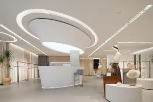 Modern minimalist retail storefront with concrete walls and potted flowers.