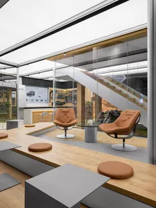 Modern showroom with wooden tables, glass dividers, and leather chairs.