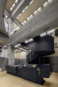 Office lobby with industrial design features, including concrete walls and structural beams.