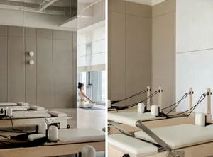 Sophisticated minimalist interior with wooden Pilates reformers, beige panels, and a serene ambiance