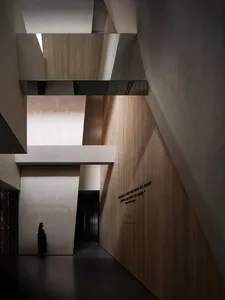 A modern interior space with concrete pillars and geometric lighting fixtures.