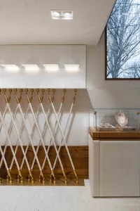 A jewelry store interior featuring a metal railing system and wooden flooring.