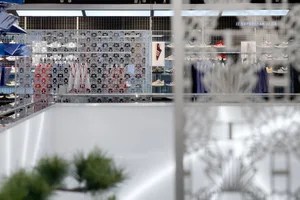 Retail space with metal grid partitions and Adidas sneakers on display.