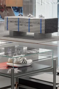 Retractable display case showcasing shoes in metallic pipes
