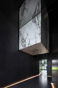 Modern minimalist interior design featuring marble elements and dark walls.