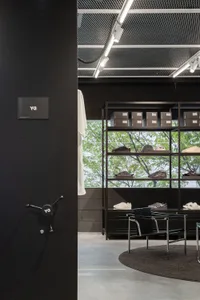 Retail space featuring minimalist design, black metal shelves, and concrete flooring.