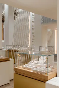 A modern jewelry shop featuring glass displays, wooden shelves, and metallic accents.