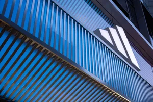 Modern metallic facade with vertical slats and illuminated logo