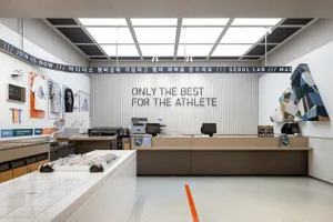 A modern minimalist storefront with concrete walls and floors, featuring a sleek counter and retail display.