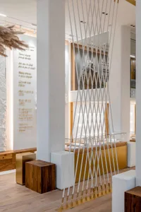 Modern retail store featuring wooden and metal furniture, rope decor, and glass windows.