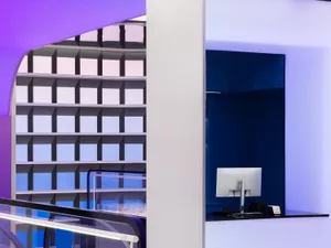 A modern office space with a glass counter and colorful cubes on the wall.