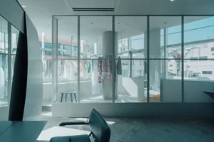 Minimalist clothing display area featuring glass walls and modern design.