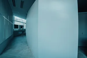 Modern office with a curved concrete wall.