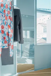 A modern interior clothing display featuring floral fabric hanging on a wall.