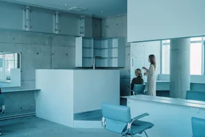 A minimalist office space with a glass cubicle