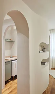 Modern minimalist kitchen with white walls, shelves, and cabinets.
