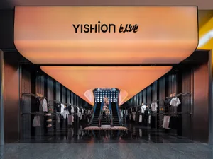 現代零售空間內的 Yishion 服飾店，設有玻璃牆、金屬欄杆與混凝土地板。