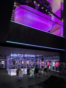 A minimalist retail space featuring metallic display stands and apparel.