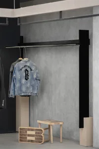 A modern clothing retail display featuring a concrete floor and a metal structure.